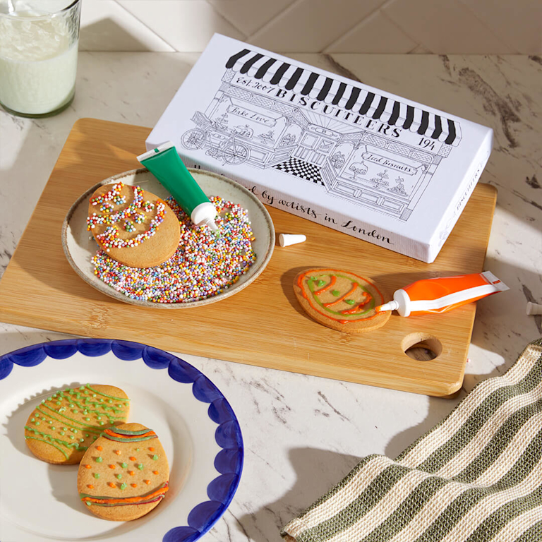 A creative DIY kit featuring egg-shaped gingerbread biscuits, tubes of colourful icing and multi-coloured sprinkles.