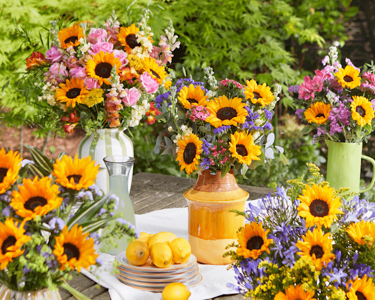 A selection of Bloom & Wild sunflower bouquets arranged across a garden table.
