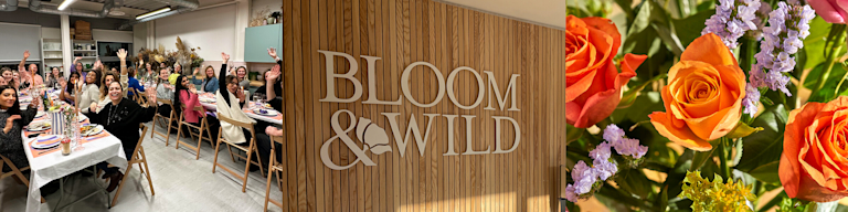 A smiling, waving group of around 20 Bloom & Wild employees sitting round tables in the office, made up of different ethnicities and nationalities.
