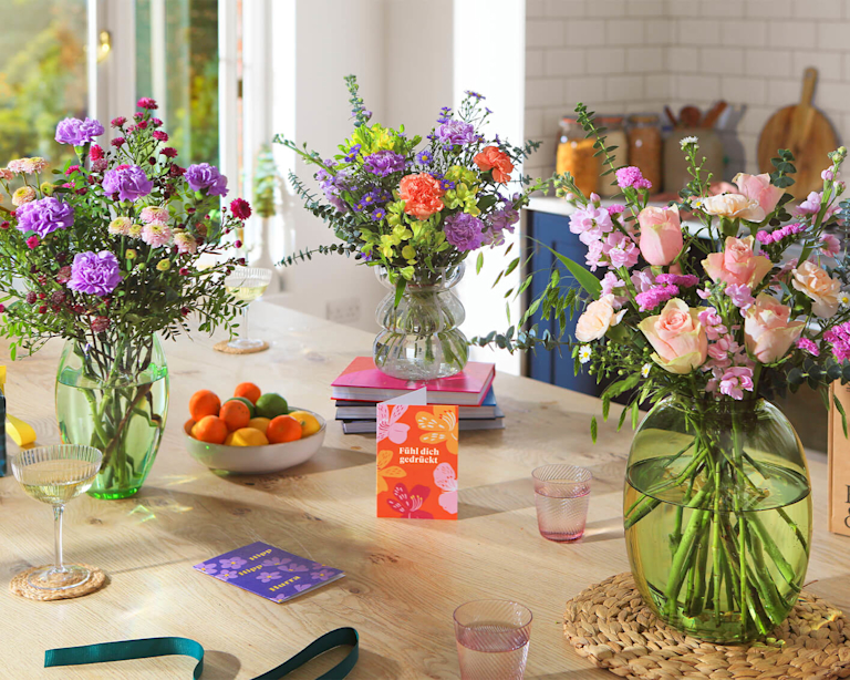 Blühend schöne und farbenfrohe Blumensträuße stehen auf dem Küchentisch