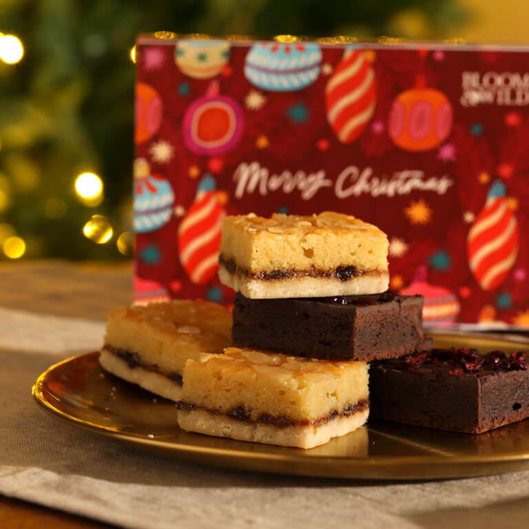 A selection of Bloom & Wild fresh baked brownies sit on a gold plate.
