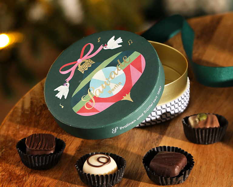 Open box of Sawade chocolate displayed on a dark oak side table