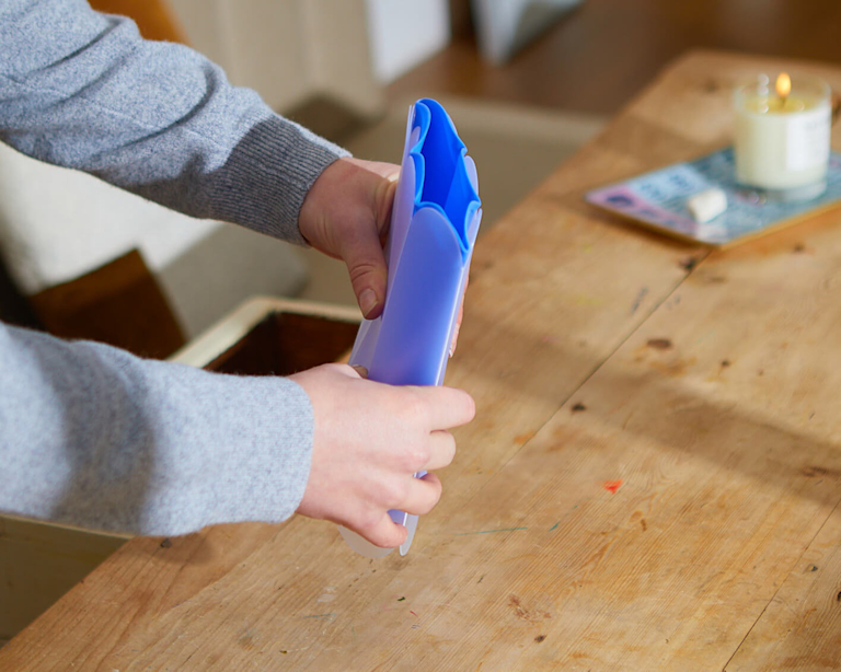 A woman pinches a letterbox vase closed.