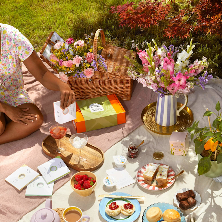 A Summer picnic, with scones, strawberries, and Bloom & Wild flowers in a vase.