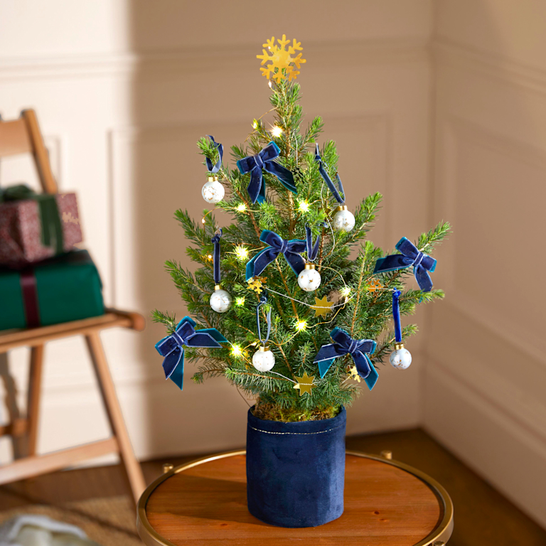 A miniature Christmas tree, decorated with snowflakes and bows