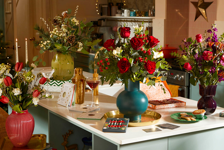Eine festlich aussehende Küche mit schönen Blumensträußen und weiteren Geschenken