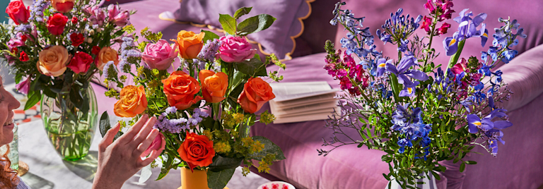 Drei blühend schöne und frische Blumensträuße in verschiedenen Farbkonstellationen stehen auf dem Couchtisch.