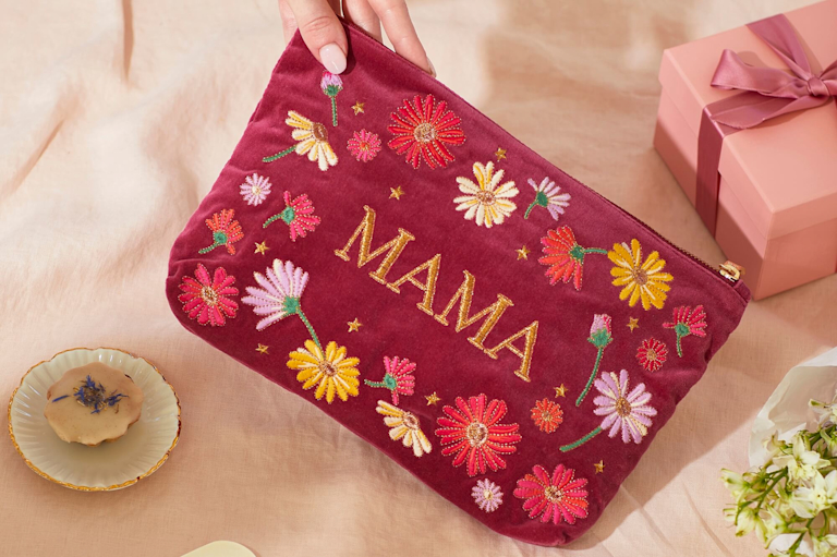 An assortment of vibrant bouquets, greetings cards and sweet treats are dotted around an open space, against a deep green background. The Bloom & Wild and Liberty logos appear over the top.