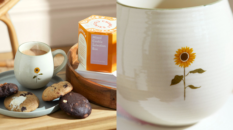 A Sophie Allport sunflower mug, next to a plate of chunky chocolate chip cookies. Next to it is a detailed close-up of the finely painted sunflower.