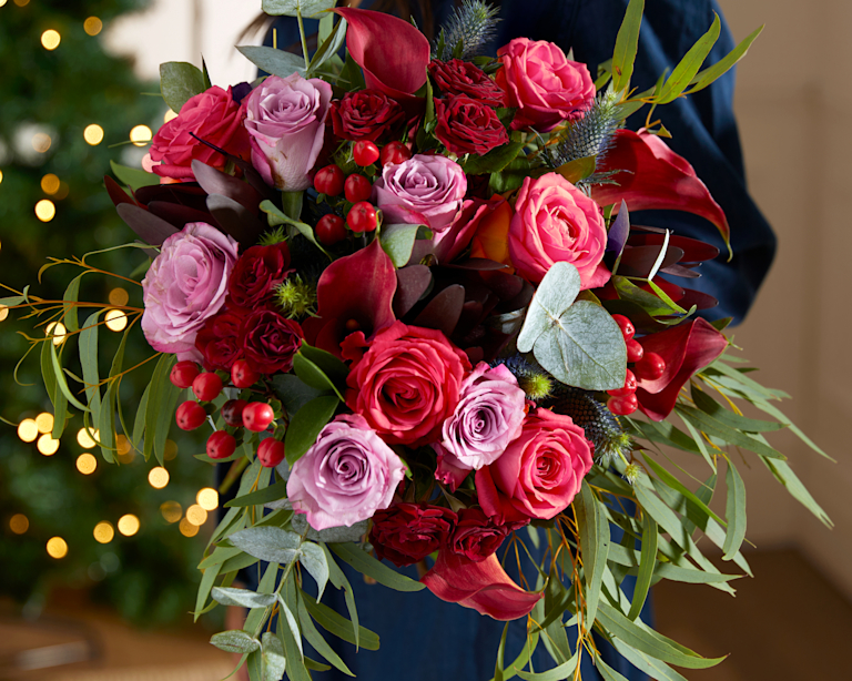 Bloom & Wild's Jingle Bell Tree - a tiny christmas tree with orange striped baubles and gold bell decorations