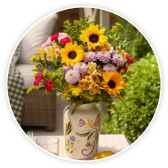A vibrant Bloom and Wild bouquet in a vase on a table