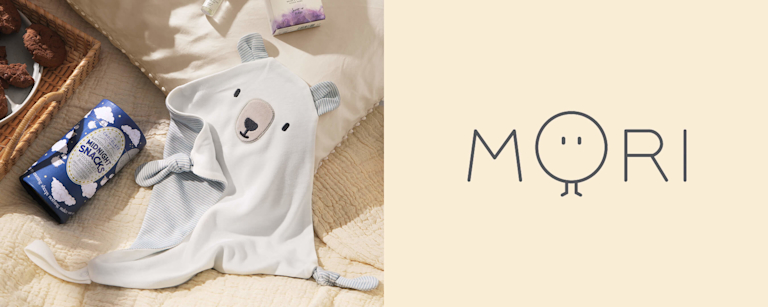 A white, grey and blue striped baby comforter in the shape of a bear's face.