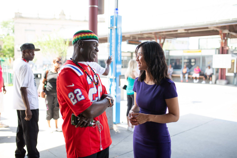 Michelle Wu speaks to a constituent at the Nubian Square bus station.