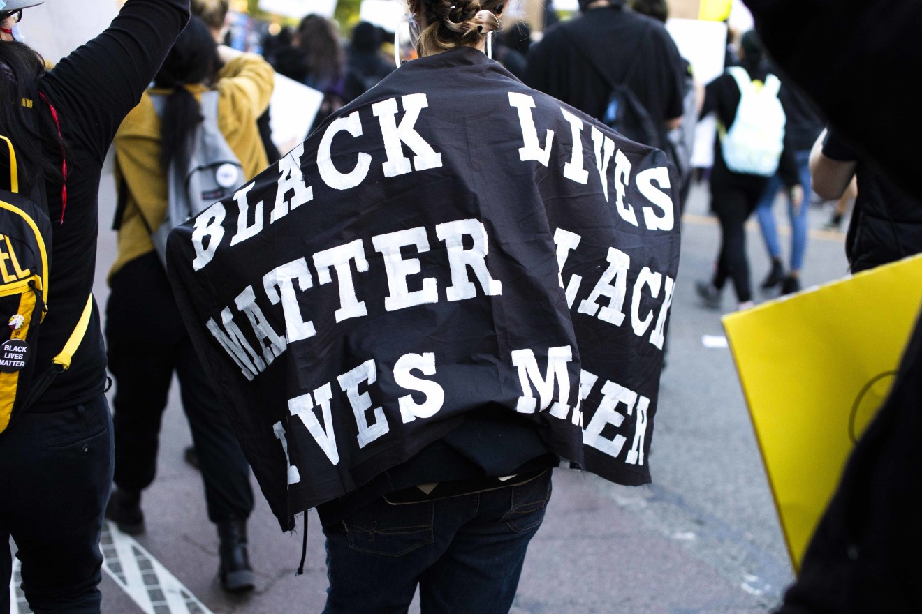 Black lives matter flagged draped over protester in Boston BLM protest.