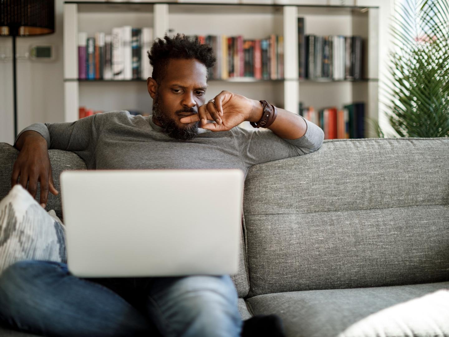 Person on sofa looking at laptop screen