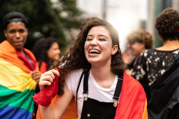 Teen with pride flag having fun at parade