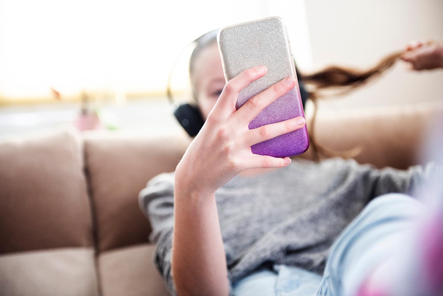 A young person looking at their smartphone.