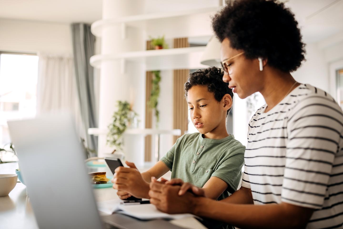 A parent and child looking at a smartphone.