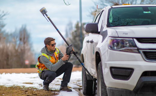surveyor near a vehicle with tilted pole
