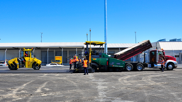 Construction crew operating a paver and compactor with Trimble Paving Control solutions on an asphalt surface