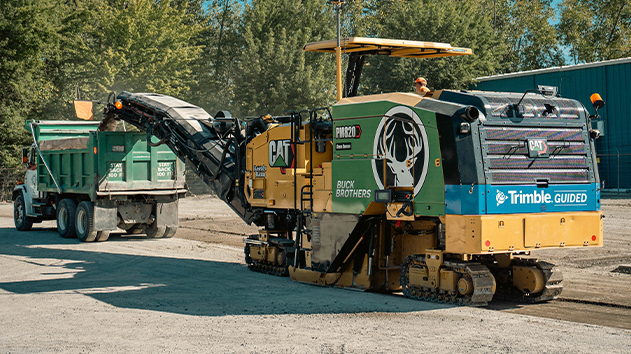 Caterpillar cold planer with Trimble Paving Control milling road surface into a dump truck