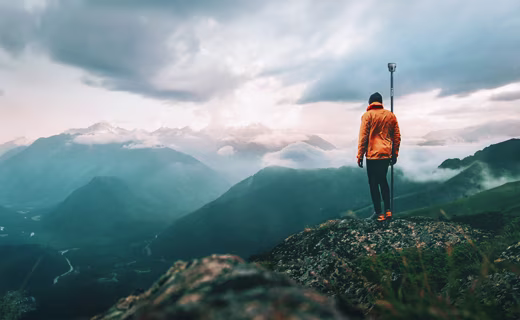 Topógrafo en la cima de la montaña
