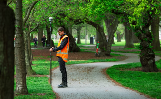 géomètre dans un parc en ville avec un mobile GNSS