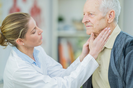 A female dermatologist checking elderly man for skin infections