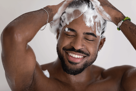 Man massaging dandruff shampoo into a rich lather to treat seborrheic dermatitis on his scalp