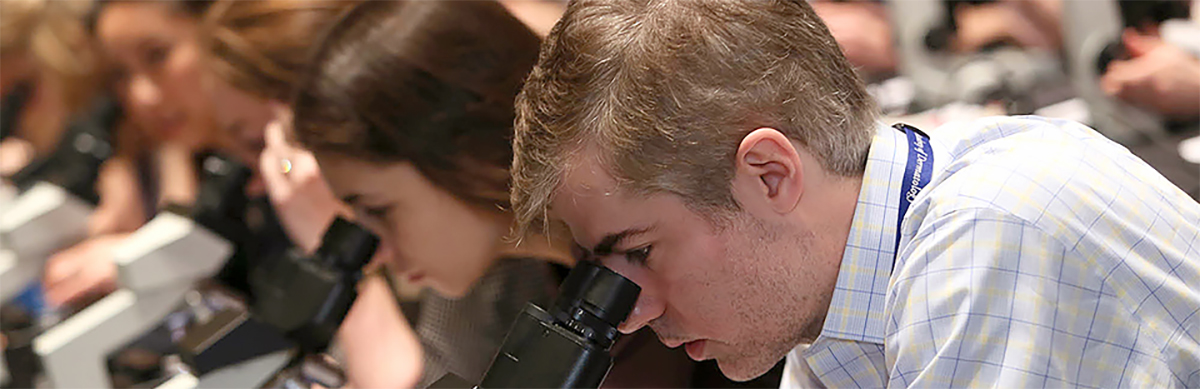 Young dermatologists looking into microscopes