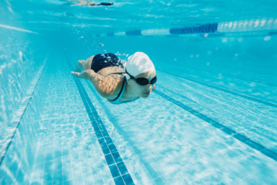 Woman underwater, swimming laps in pool