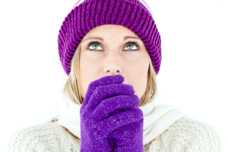Woman blowing on hands to keep warm