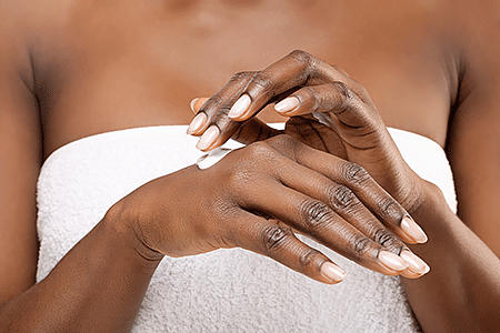 Woman applying moisturizer to her hand