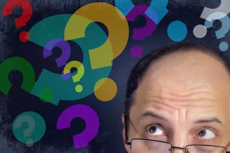 Man looking at question marks expressing confusion