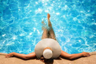 Person in a pool with a sun-hat