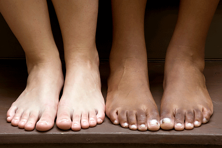 Close-up of bare feet for a Caucasian person and an African American person