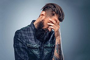 Stressed man with tattoo on his arm
