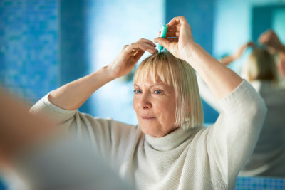 woman applying medicine to scalp