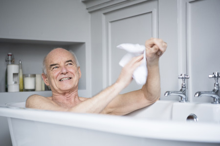 Senior man in bath washing himself