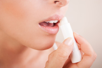 Woman applying lip balm to her healthy lips