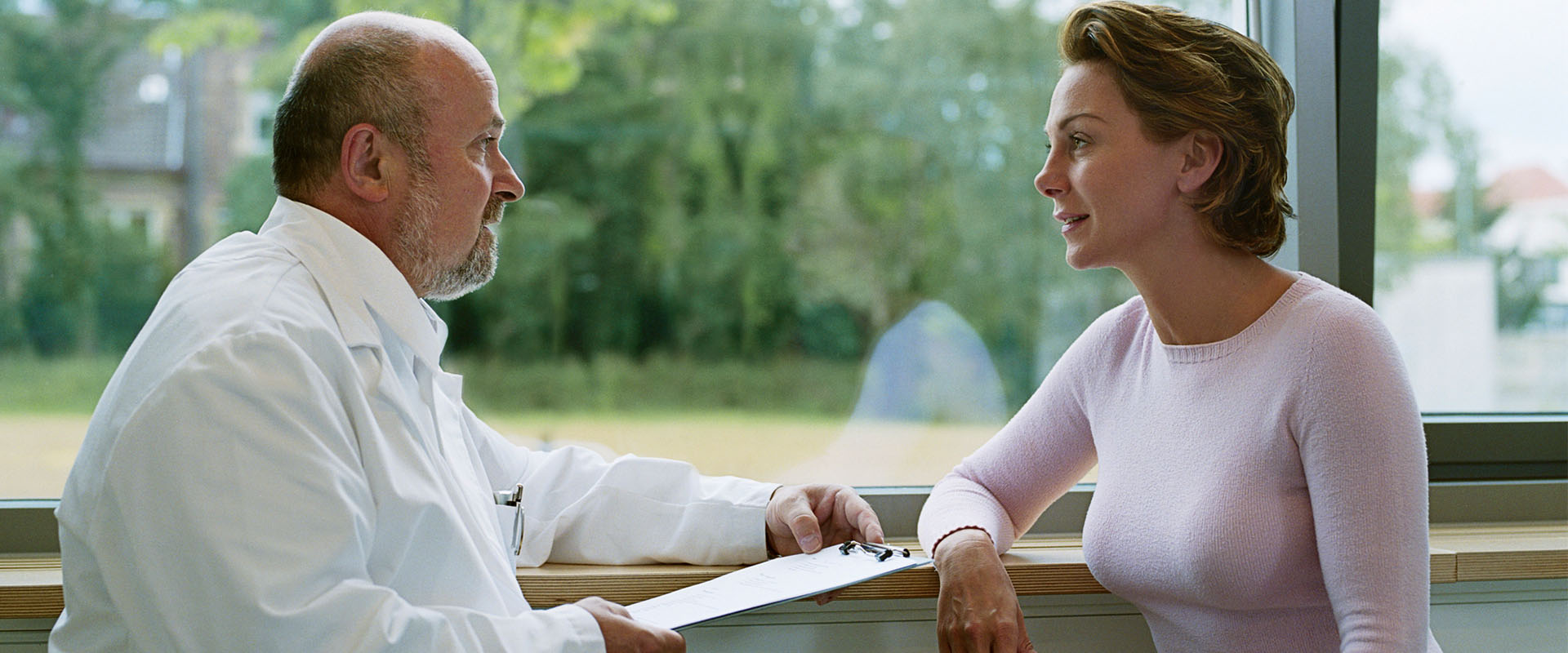 Dermatologist reviewing paperwork with a patient