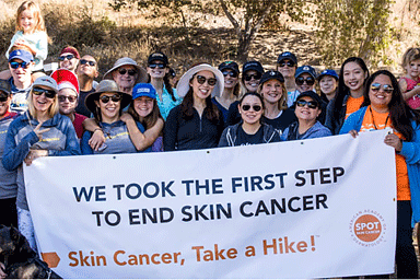 Group of people holding a sign for AAD's Skin Cancer, Take a Hike!™