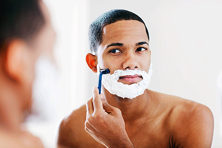 Man shaves, using a thick layer of shaving cream