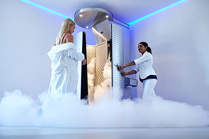 Woman stepping into cryotherapy chamber