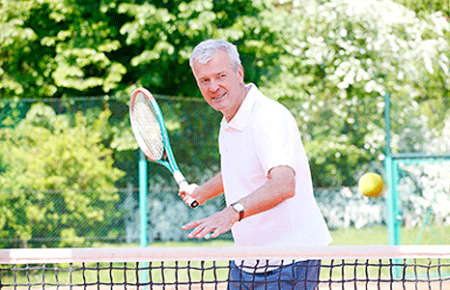 Older gentleman playing tennis