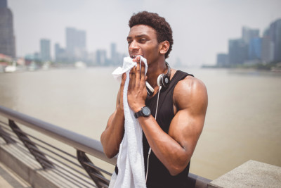 Man wiping face after exercise