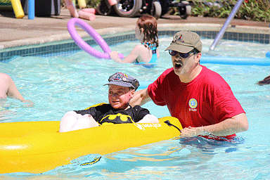 Counselor playing with camp kids in pool