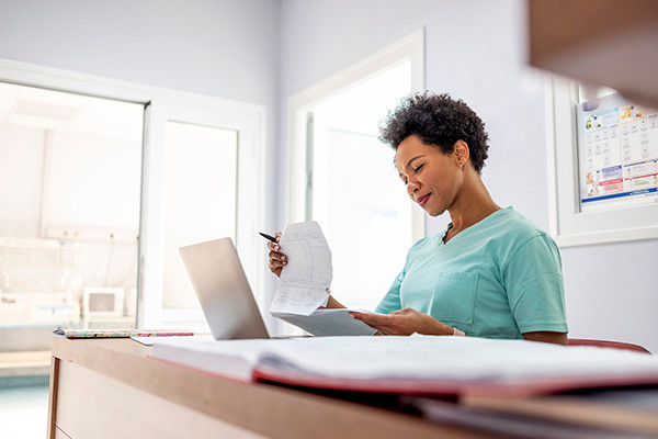 Image of a clinician reviewing prior authorization paper work to help patients receive care