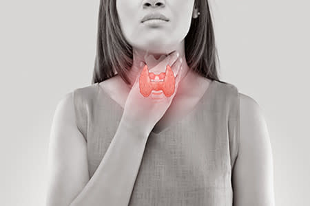 Girl rubbing neck with thyroid gland image overlay