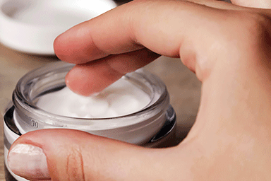 Applying moisturizer to hand.